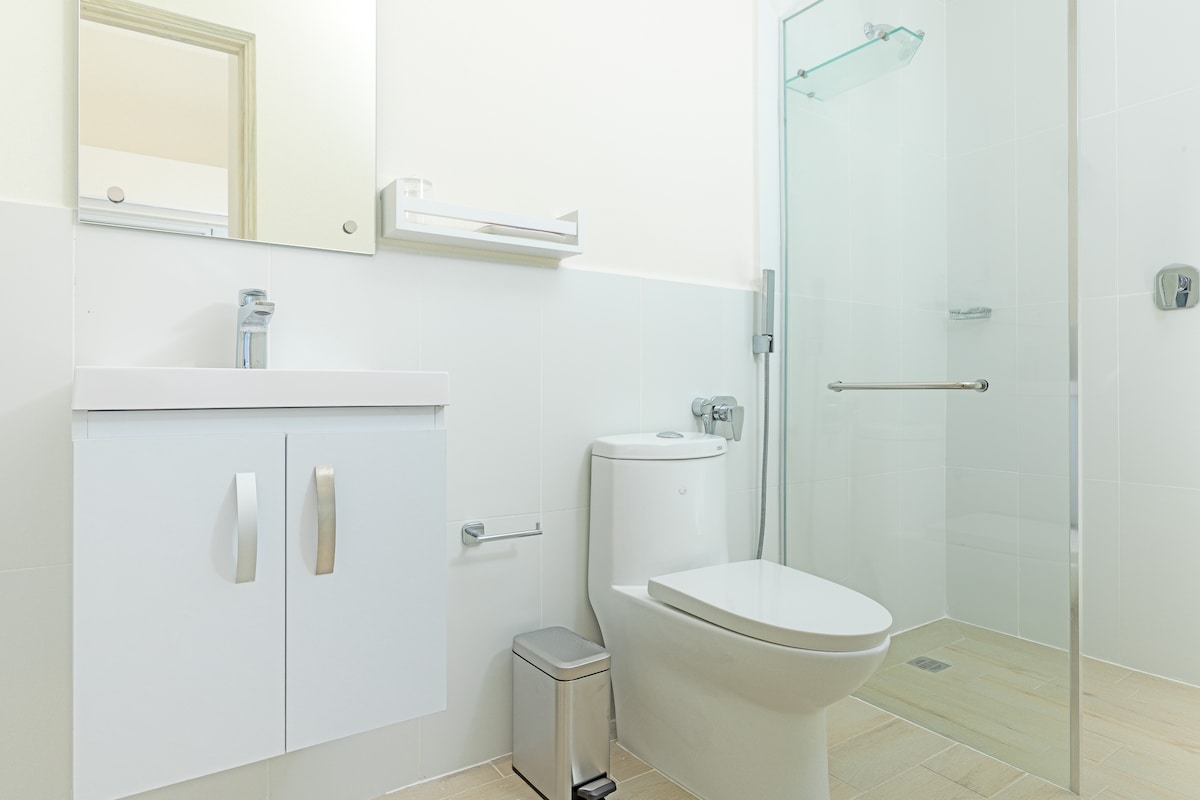 Modern white bathroom with walk-in shower in Penthouse 900-7
