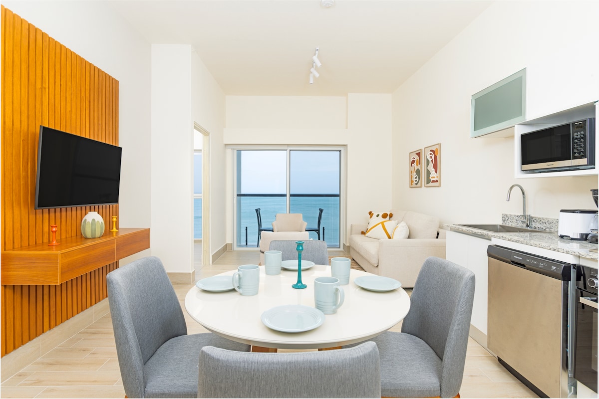 Living room, dining and kitchen with ocean view through balcony in Penthouse 900-7 at Playa Caracol