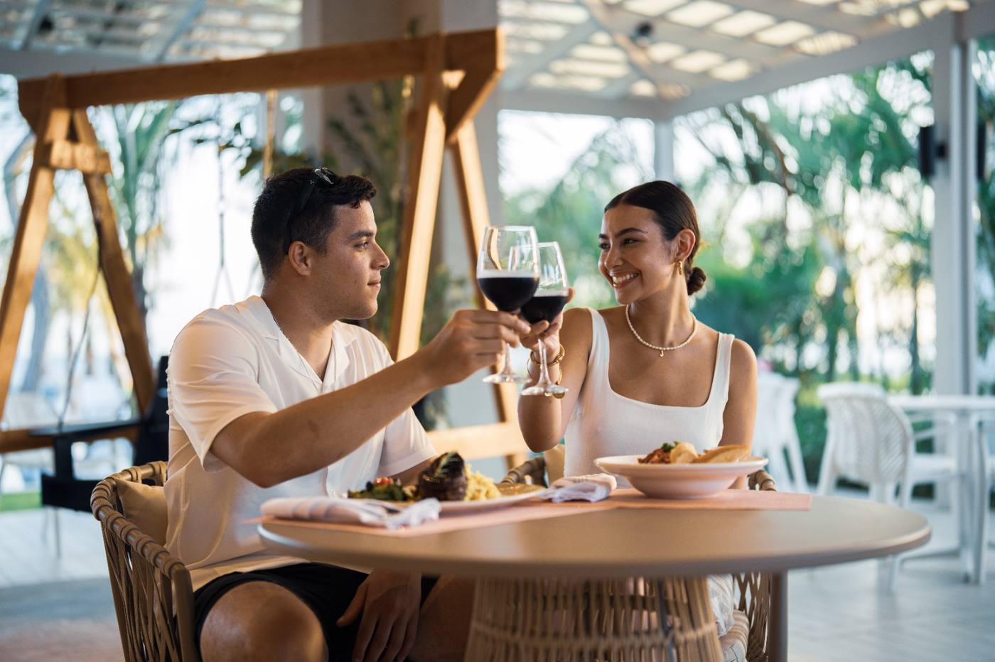 Couple toasting wine at an open-air restaurant at Playa Caracol