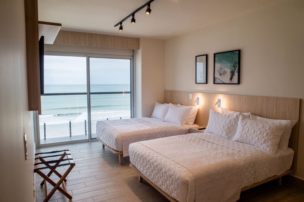 Bedroom with two beds and ocean view in Radisson Suite 502b at Playa Caracol