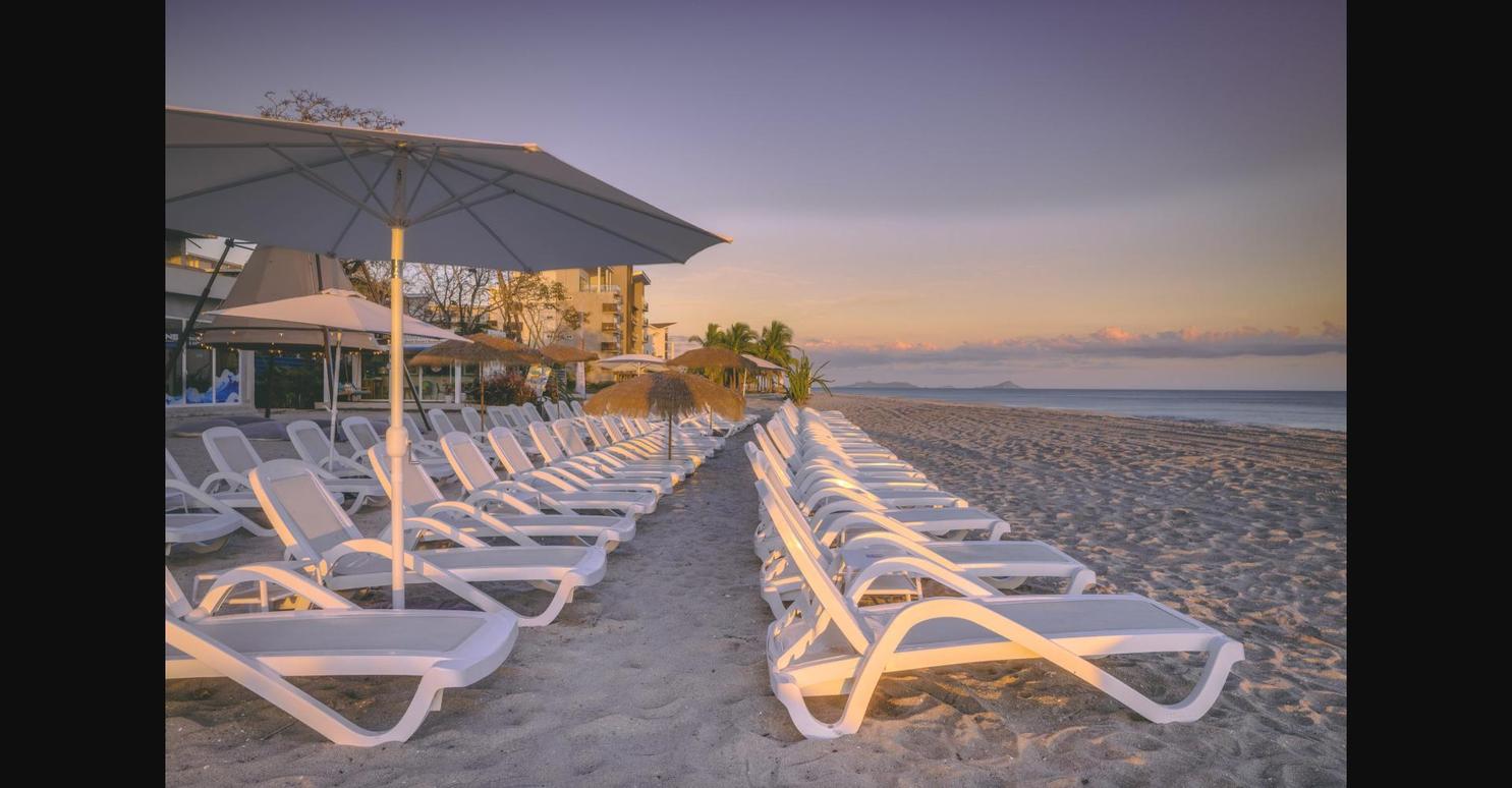 Beach loungers and umbrellas at sunset on Playa Caracol, Panama